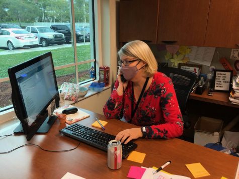 Director of College Counseling Ms. Anna Wright makes a phone call to a college. Despite applications being sent in first semester, the college counselors stay busy in the second semester helping juniors.