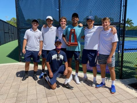 The Varsity Boys Tennis Team holds the District Champion Trophy.