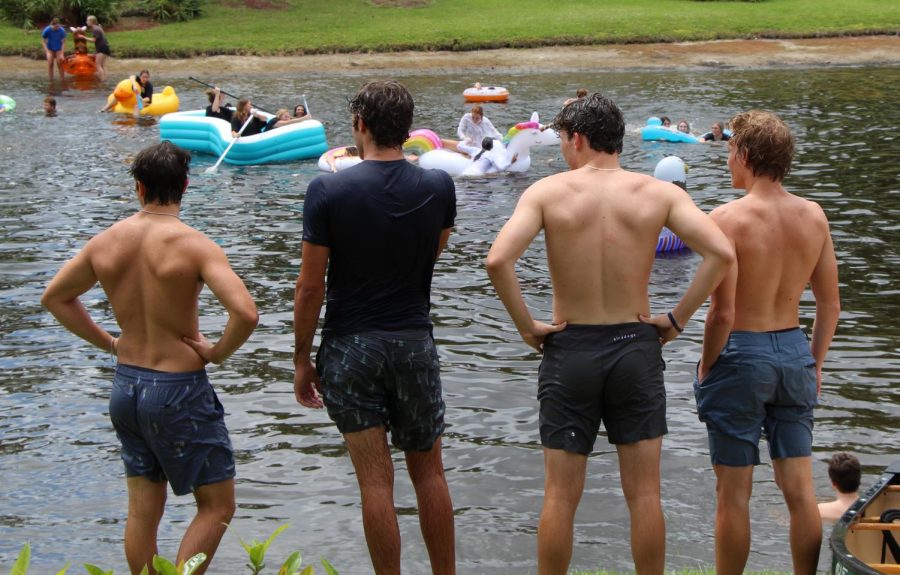 (L to R) Seniors Lukas Burnett, Nick Lutz, Andrew Pagano, and Lenny Lindahl watch their classmates enjoy themselves in the School lake on Apr. 30. Despite an unorthodox year due to COVID-19, the annual lake jump proceeded as normal.