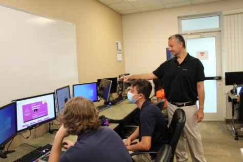 Computer teacher Mr. Brian Bray acts like a human mouse, pointing to to the screen as he instructs students in AP Computer Science.