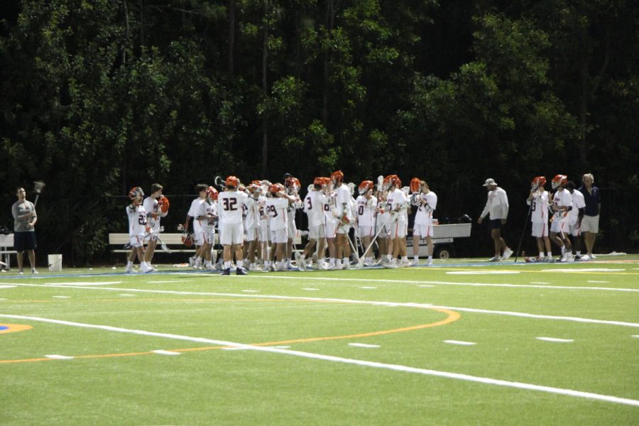 The boys’ varsity lacrosse team gathers during a game to discuss the recent plays. The team has a record of 8-3 and has their next game on March 29 at Miami Country Day.