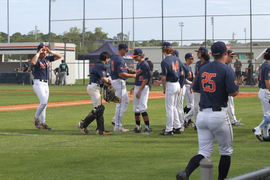 The varsity baseball team is pictured celebrating a successful play during one of their home games. The team is lead by seniors Gerald Bissell, Jake Haggard, and Max Joy.