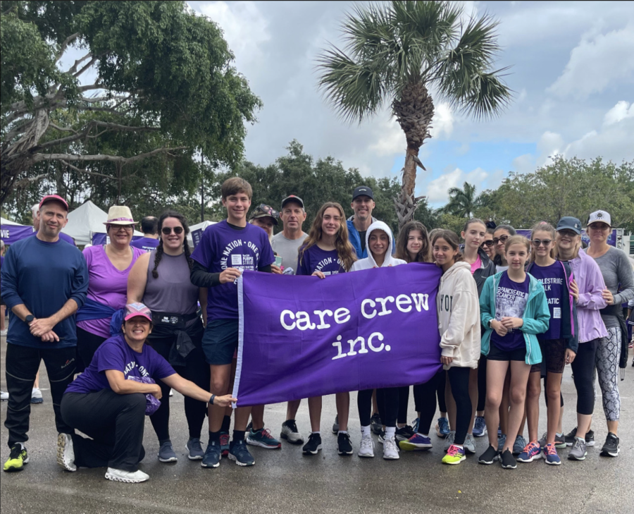 Members of Care Crew and their parents pose with a large Care Crew flag. The
nonprofit has helped many within the local community.