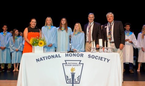 Head of Upper School Fletcher Carr and Head of School David Faus stand on the stage with three students who were inducted into the National Honor Society as well as Ms. Misselhorn who leads NHS at Benjamin.
