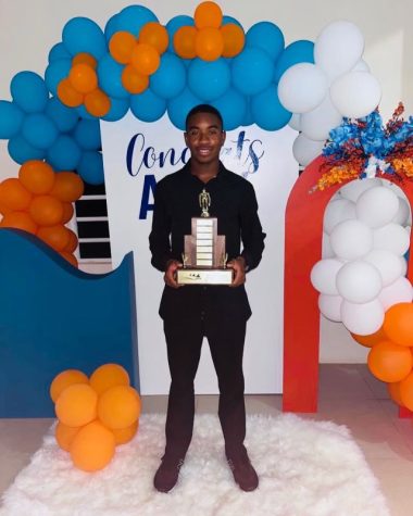 Senior Alex Lake poses with his national records trophy that he received for setting Anguillian swimming records. He is the leading Anguillian in the 50m and 100m freestyle, 50m backstroke, and 50m and 100m breaststroke.