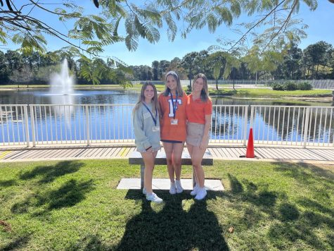 Treasurer and sophomore Vanessa Zito (left), president and junior Maggie Smith (middle), and historian and junior Ella Womble (right) pose for a picture in front of the lake.
