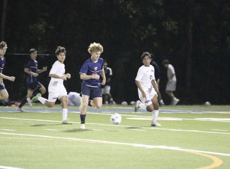 Sophomore Ford Cash runs past American Heritage defenders to set up a shot towards the goal.