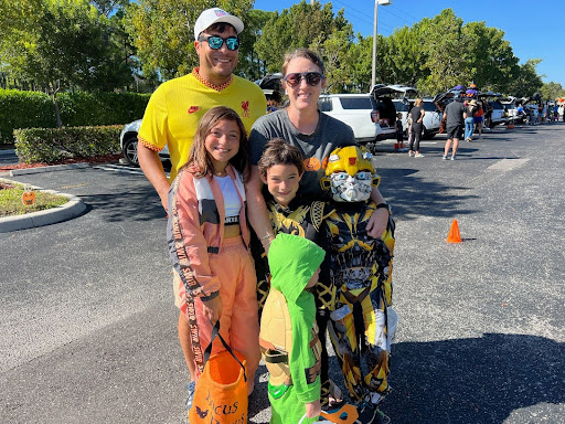 Upper School Dean of Academics and World History Teacher Mrs. Caroline Guzman poses with her family as they attend “Trunk or Treat.”
