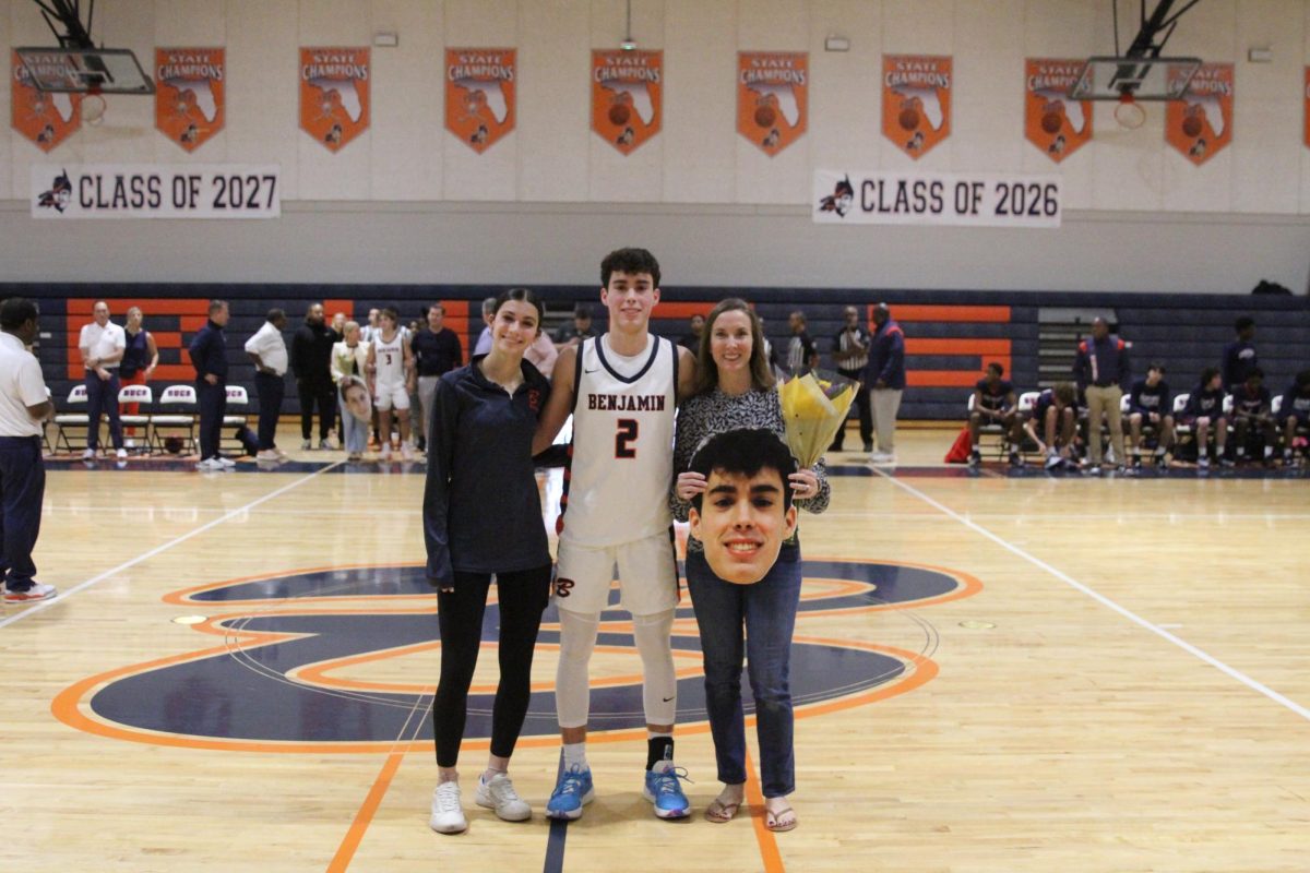 Senior Christian Balistreri takes a picture with his sister and mother during Senior Night for the Boys Varsity Basketball team. Balistreri was named a captain for a second consecutive season on varsity.