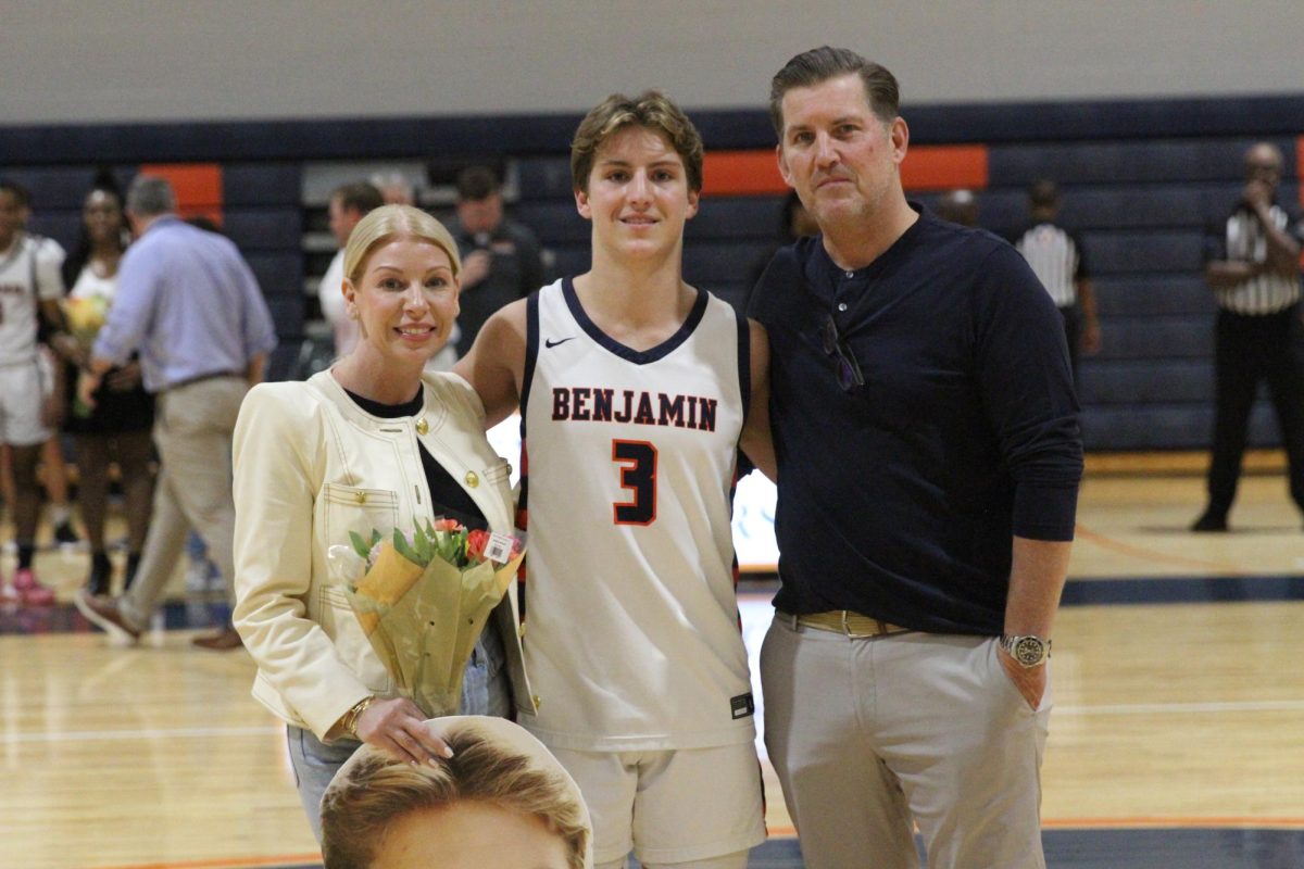 Senior Hudson Byrne takes a picture with his parents during Senior Night. Hudson and his brother Leo Byrne 23 were both four year members of the basketball team.