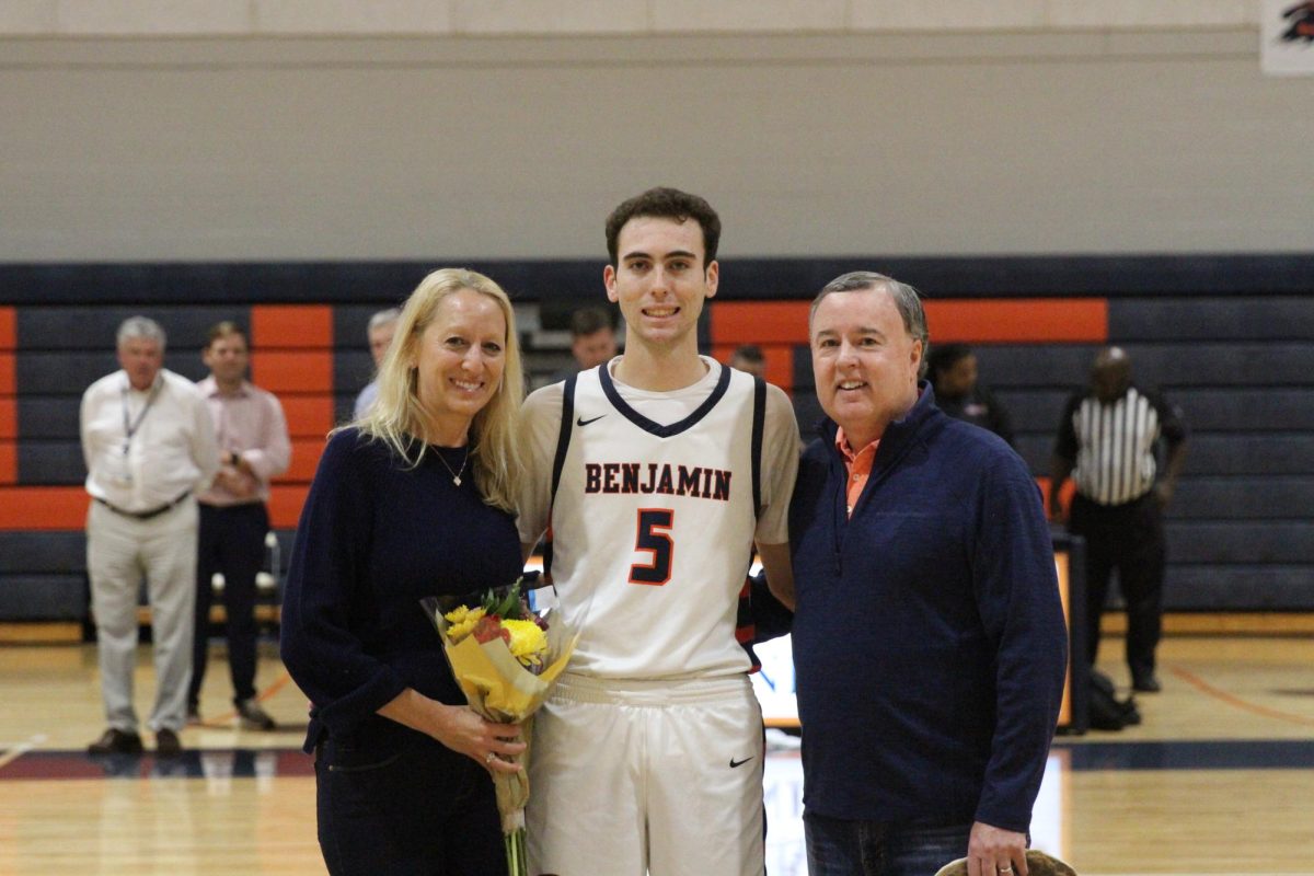 Senior Joey Tomassetti takes a picture with his parents on his senior night. Along with playing basketball, Tomassetti also enjoys watching the sport. The Miami Heat are his favorite team.