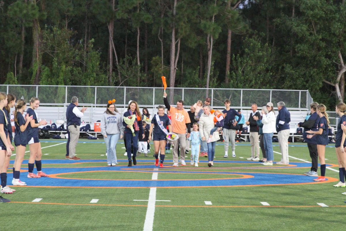 Senior Natasha Yedinak parades down the field alongside her family celebrating her commitment to soccer.