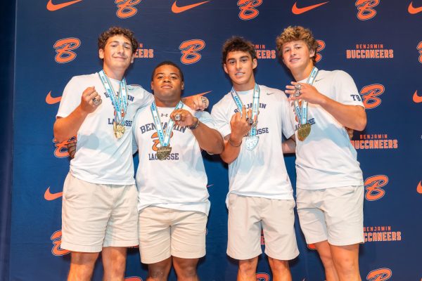 Seniors Jake Froot, Terrion Ivy-Atkins, Tatum Little, and Chase Conner pose for a photo with their State Champion rings and medals. 