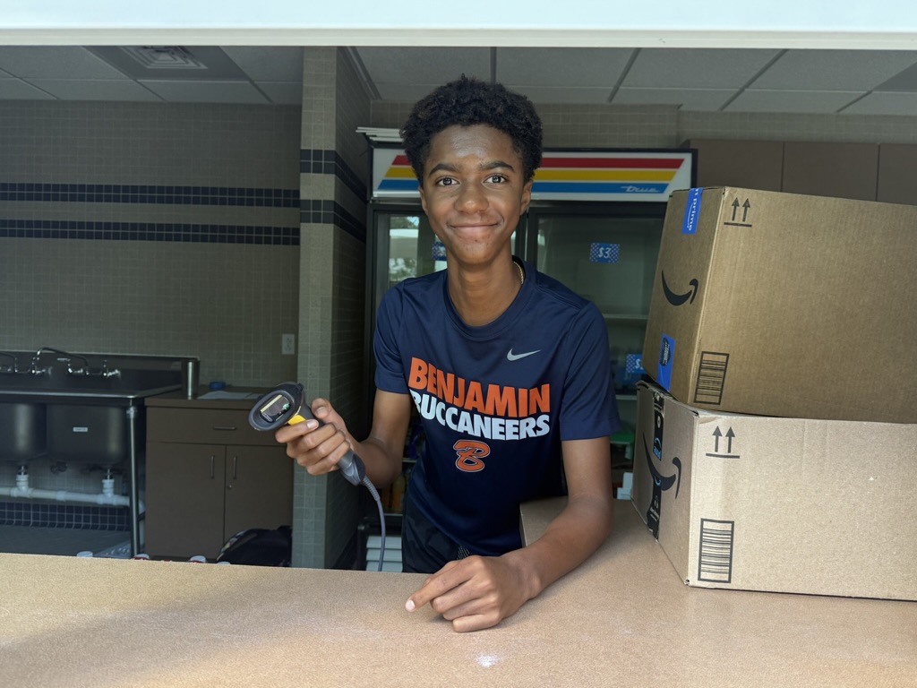 Freshman Daschle Searcy greets students with a smile and scans items during his Tuesday concession stand duty.