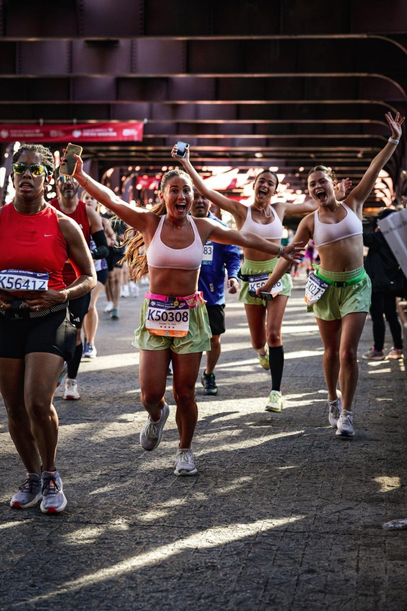 Senior Kenna Kujawa (right) nears the finish line of the Chicago Marathon with her sister, junior Zeta Kujawa (middle), and junior Ziva Garaj (left)