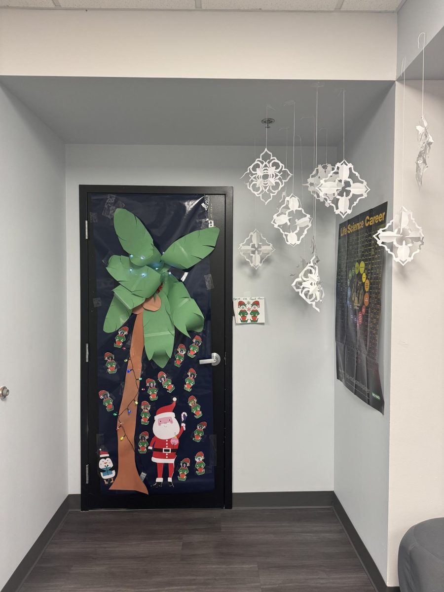The winning advisory in the freshman class was Ms. Szleiga’s advisory. They created a Florida Christmas scene with a cutout palm tree, floating snowflakes, Santa, and each advisory member as an elf. This door was especially impressive due to the real lights strung around the tree and the cutout snowflakes that were suspended in-air using wire. 

